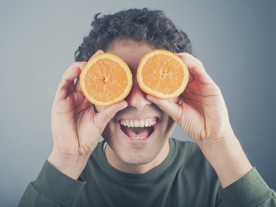 man using oranges as binoculars